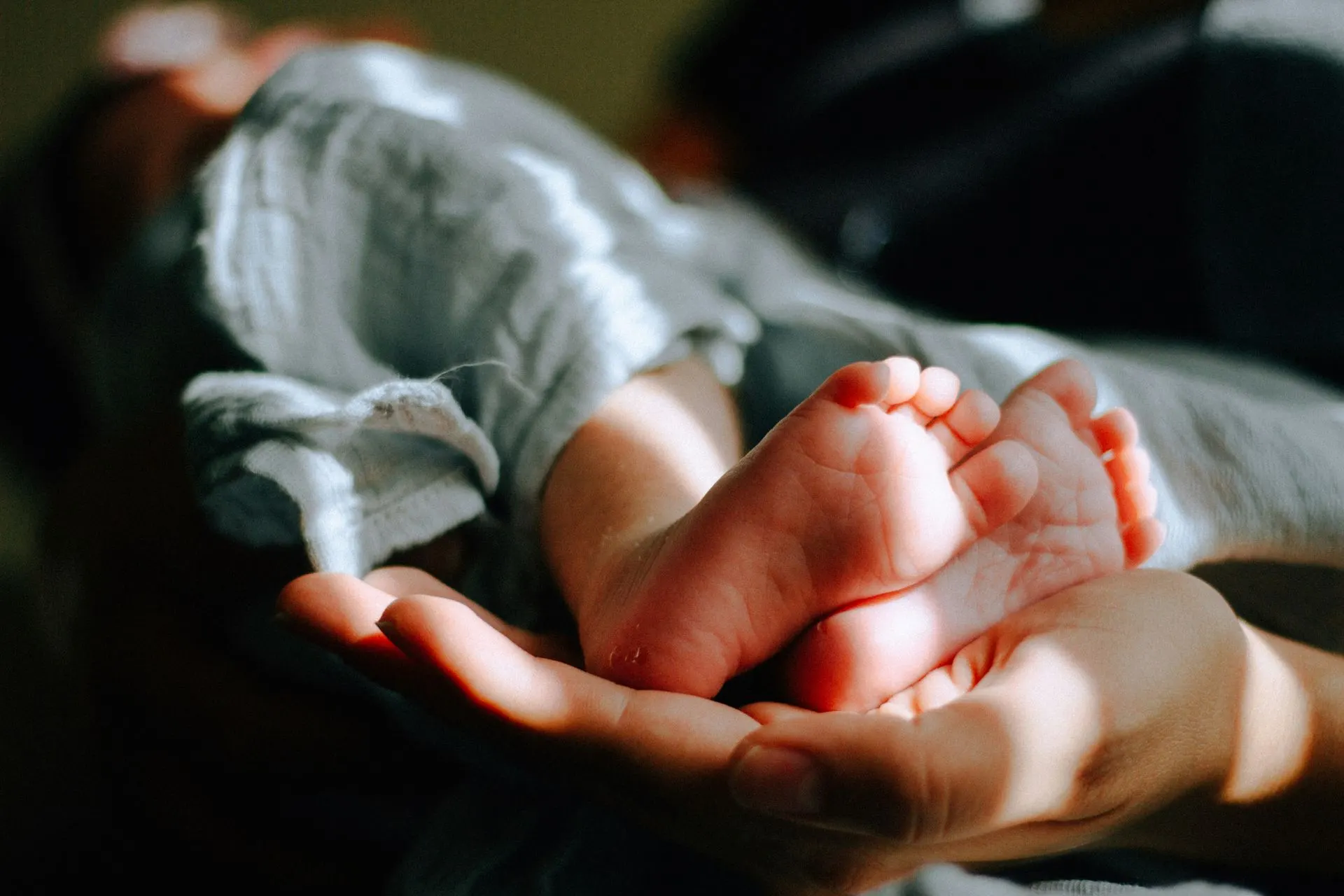 Parent holding a newborn's feet, couples therapy after baby in Charlotte, NC
