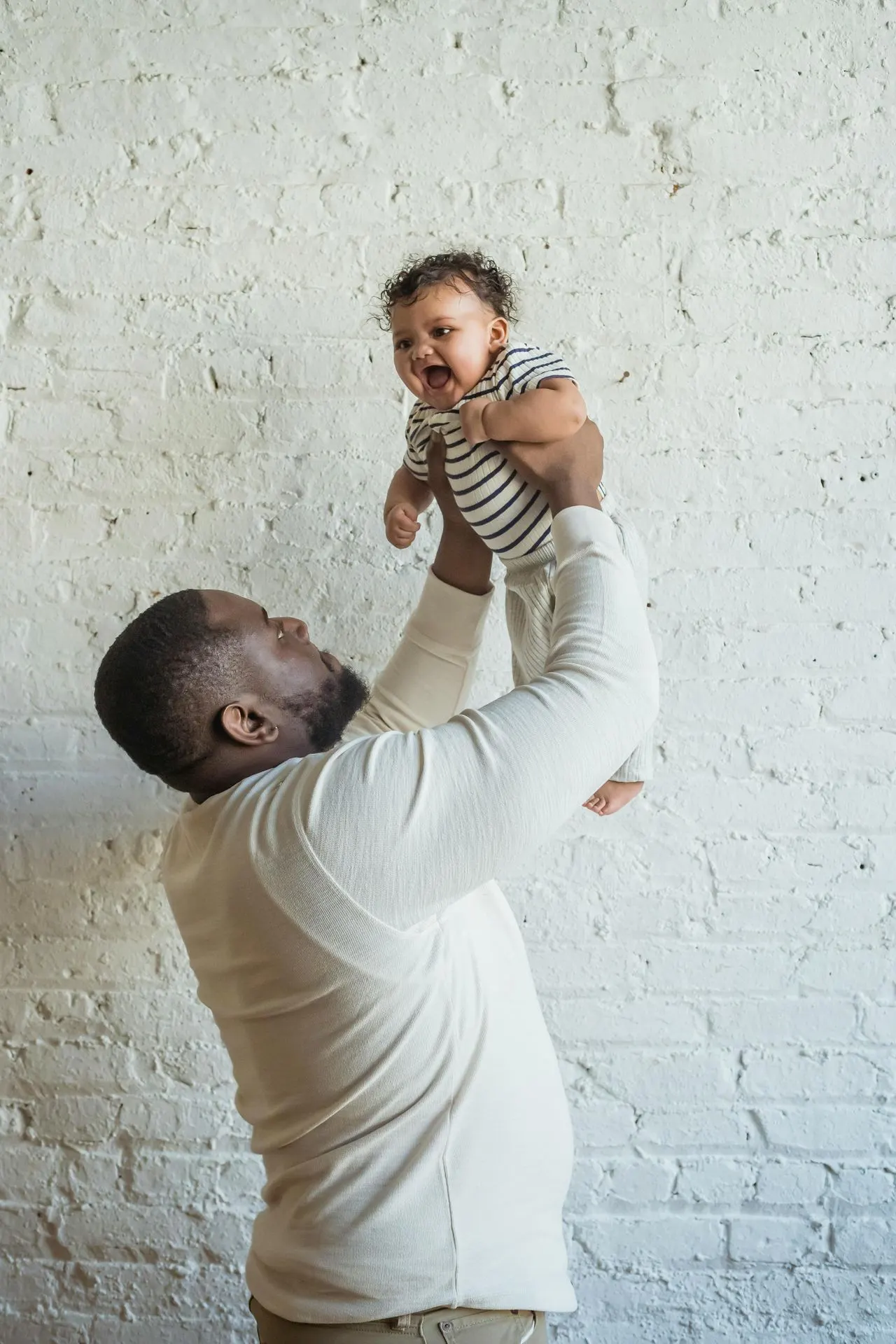 Father lifting his baby, postpartum depression in fathers in Charlotte, NC