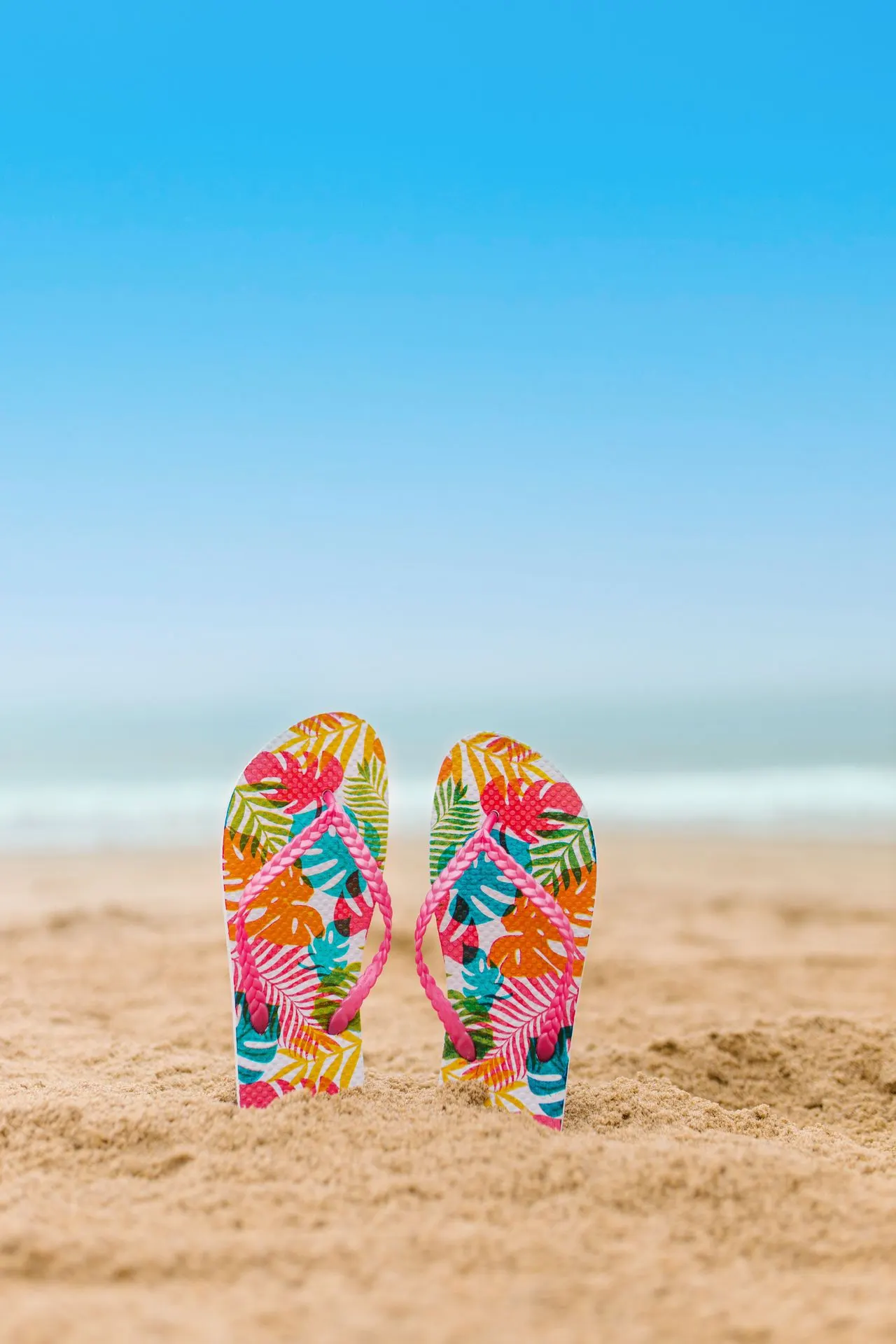 Flip flops in the sand at the beach, summer stress for parents