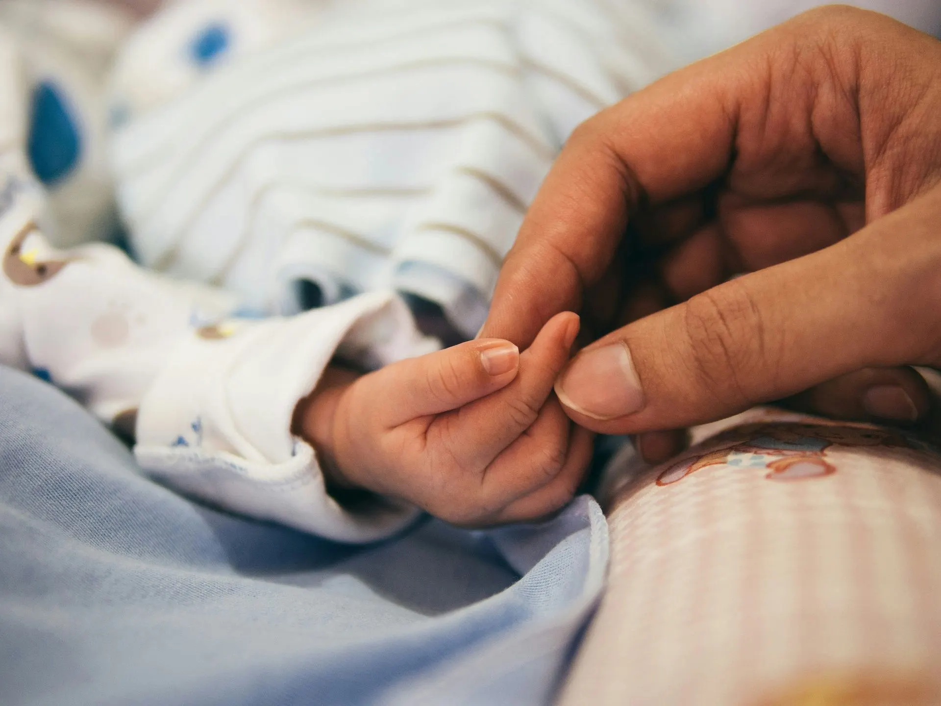 Parent holding a newborn's hand, postpartum depression treatment in Charlotte, NC